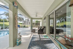 A covered patio area with a pool, wicker furniture, and decorative shells. - Little Peace Of Paradise At Willow Wood 3 Bedroom Home by RedAwning (Inverness)