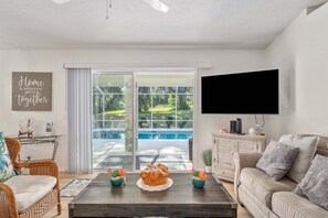 A living room with a sofa, coffee table, and a flat-screen TV.