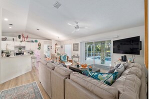 A modern living room with a large sofa, a dining area, and a kitchen. - Little Peace Of Paradise At Willow Wood 3 Bedroom Home by RedAwning (Inverness)