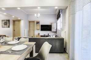 Apartamento, vista para a cidade | Área de estar | TV de tela plana