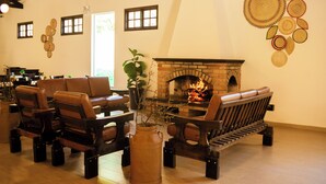 Una sala de estar acogedora con sofás de cuero, una chimenea de ladrillo y una mesa de centro.