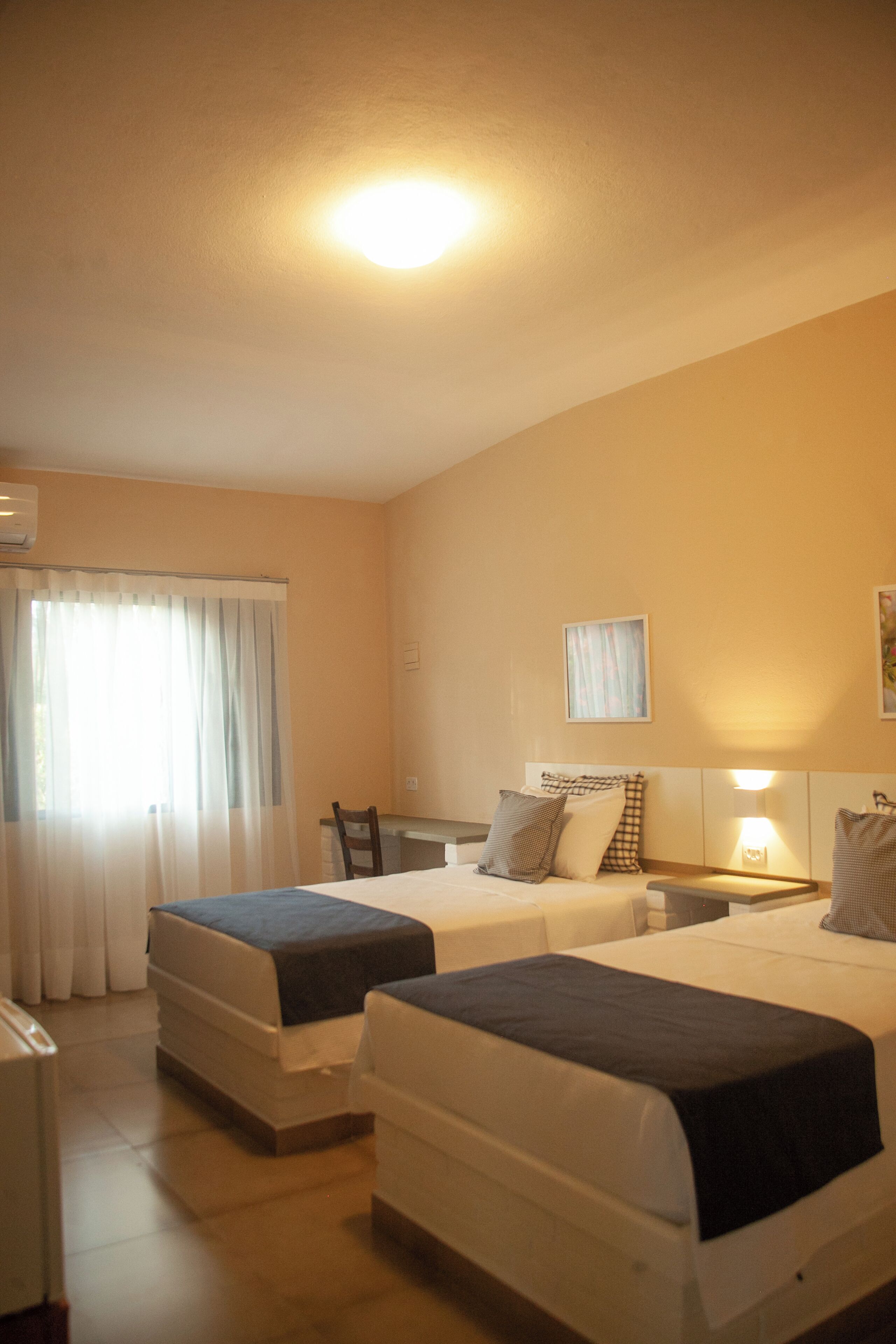 Ein Hotelzimmer mit zwei Betten, einem Schreibtisch und einem Sessel.