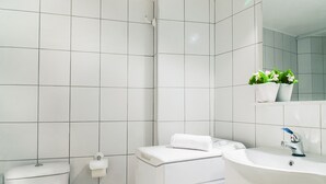Une salle de bain moderne équipée de toilettes, d’un lave-linge et d’un lavabo.