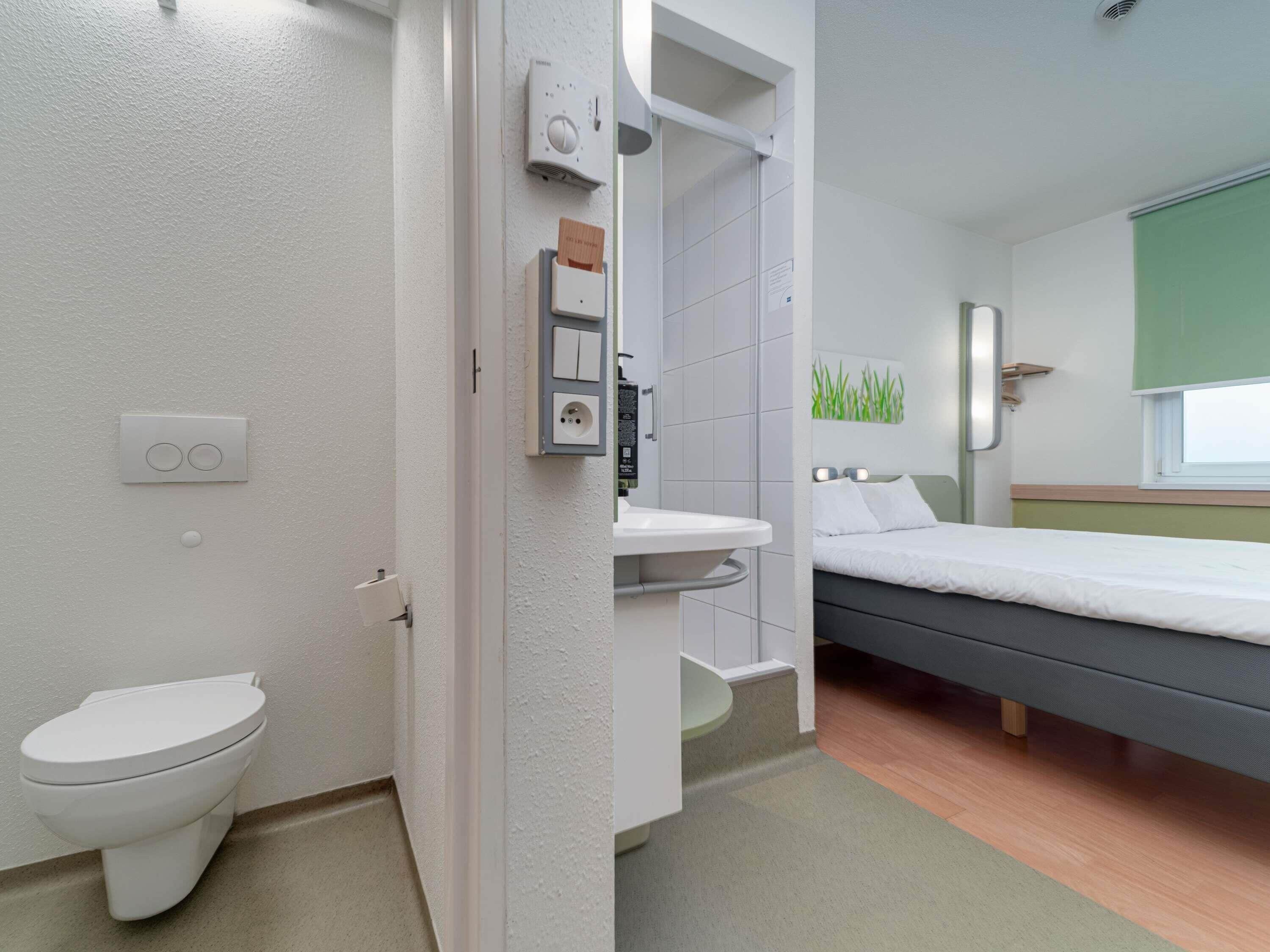 A modern bathroom with a toilet, a shower, and a sink.