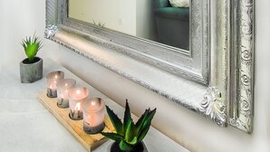 A mirror with ornate silver frame, a wooden shelf with candles, and a potted plant. - Charming 2 bdr apt next to Piraeus port (Piraeus)