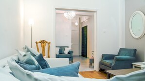 A modern living room with a sofa, armchairs, a wooden coffee table, and a chandelier. - Charming 2 bdr apt next to Piraeus port (Piraeus)