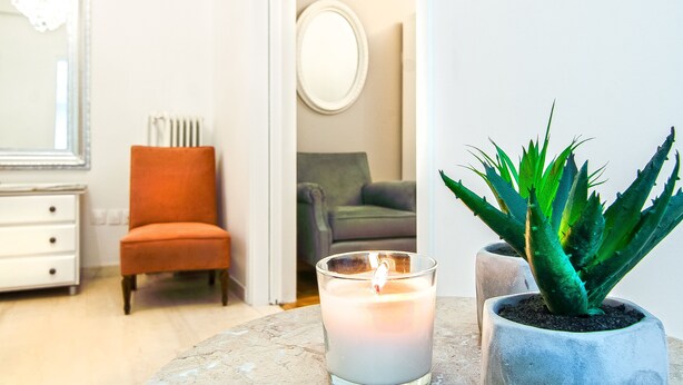 A room with a marble table, a lit candle, a potted aloe vera plant, a white dresser, and a mirror on the wall. - Charming 2 bdr apt next to Piraeus port (Piraeus)