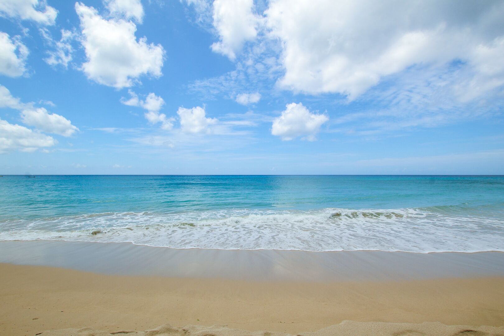 A beach with clear skies and calm waves.
