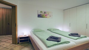 A room with a bed, a nightstand, a painting, and a wardrobe. - APART HOLIDAYS Residenza Flora (Muralto)