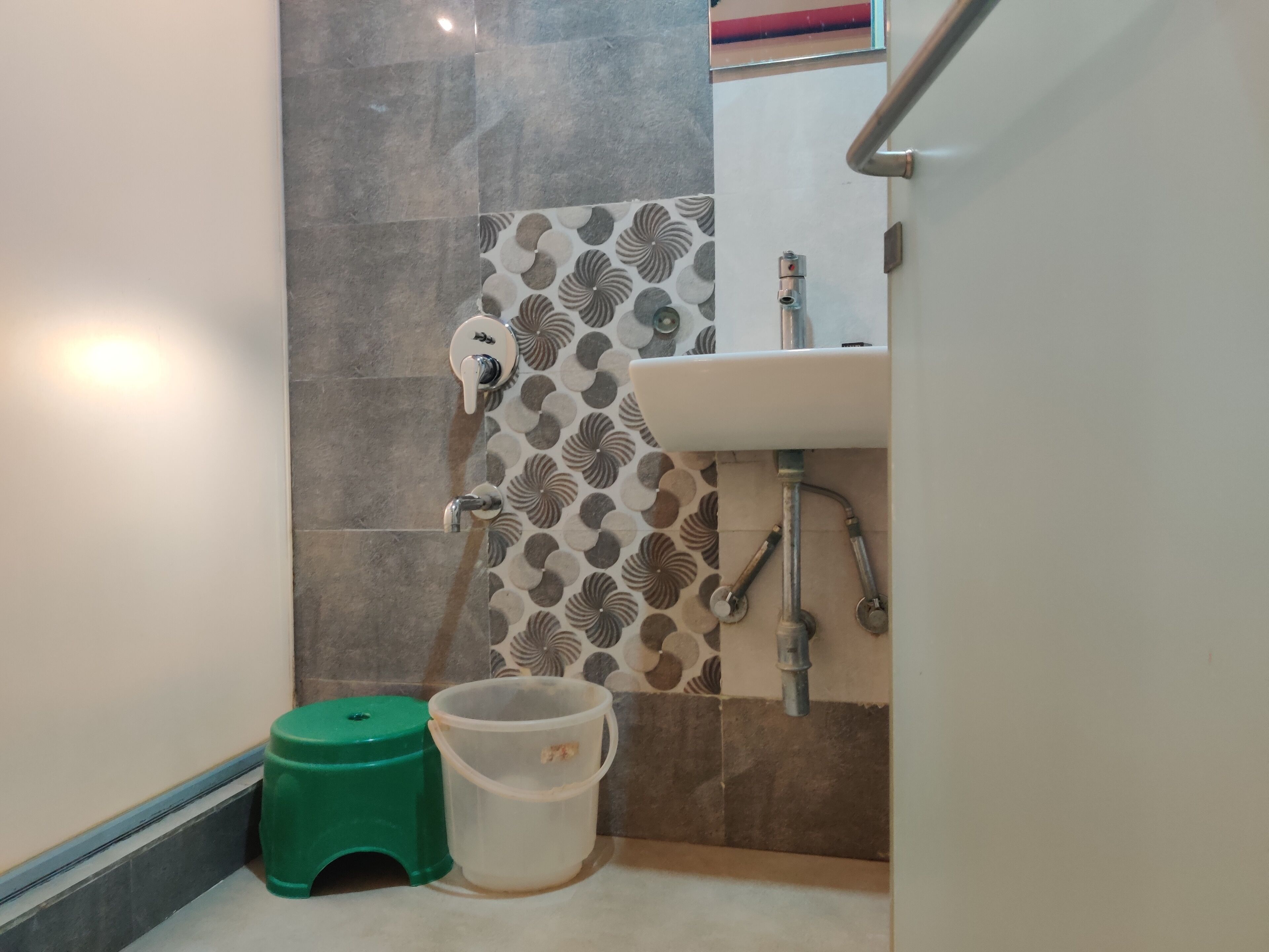 A bathroom with a sink, toilet, and green stool.
