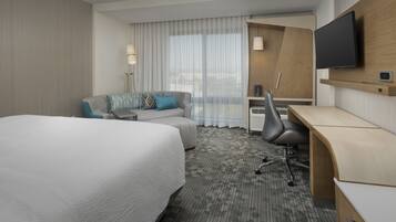 Une chambre d’hôtel avec un grand lit, un canapé, un bureau et une télévision.