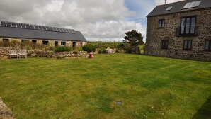 A stone building with a sloped roof and a solar panel array.
