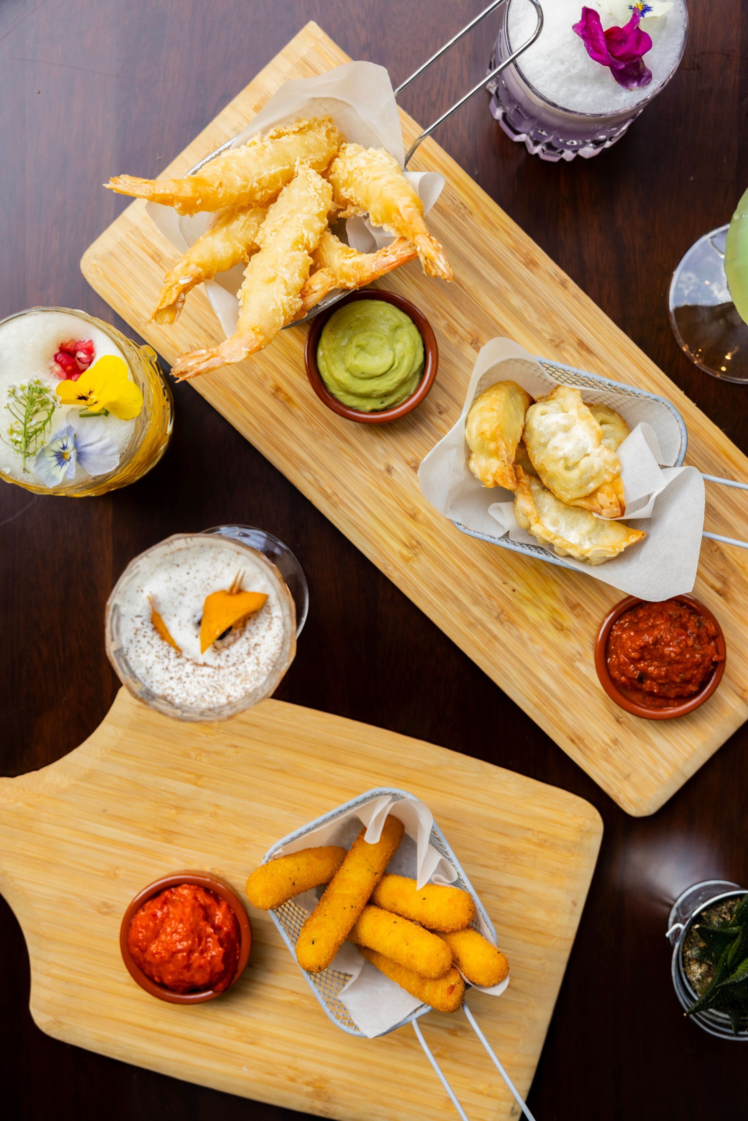 A wooden table with various food items and drinks.
