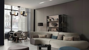 Ein modernes Wohnzimmer mit einer Couch, einem Couchtisch, einem Hocker und einem Bücherregal.