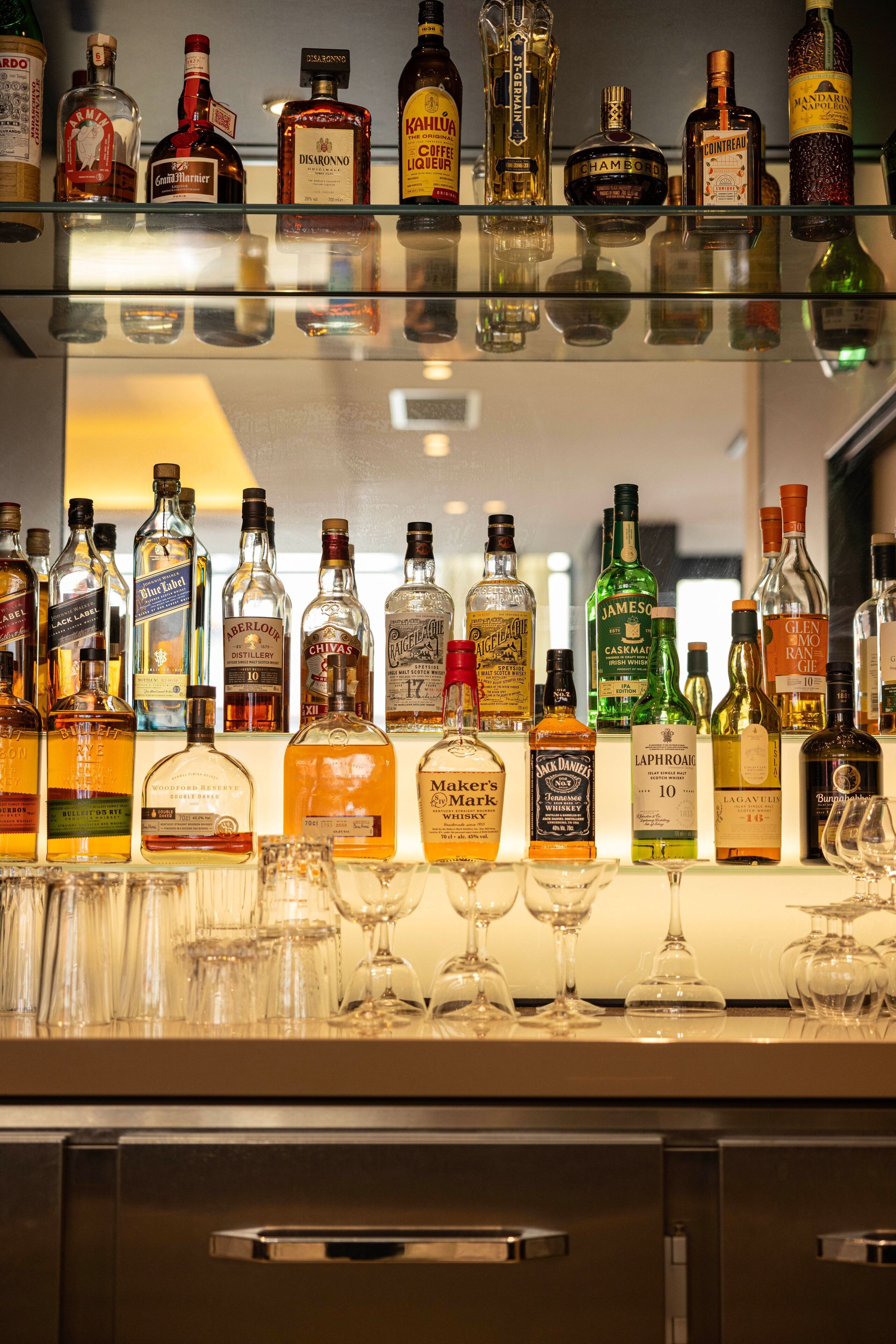 A bar area with various bottles of liquor and glasses.
