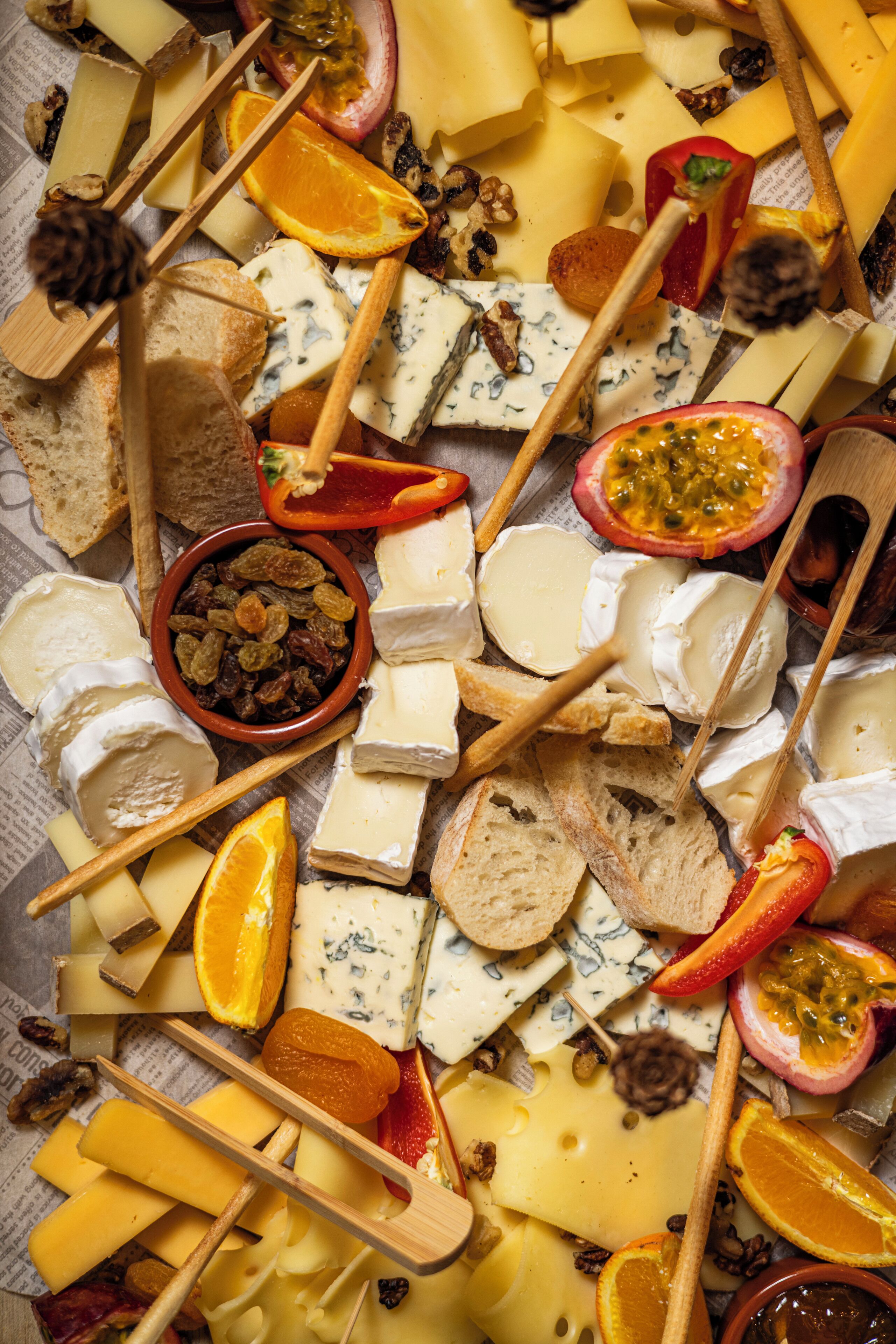 Une variété de fromages, de fruits et de noix disposés sur une surface.