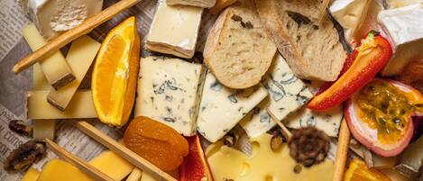 A variety of cheeses, fruits, and nuts arranged on a surface.