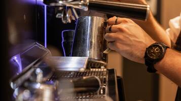 Una persona operando una máquina de café espresso, con énfasis en la interfaz de la máquina y las manos de la persona.