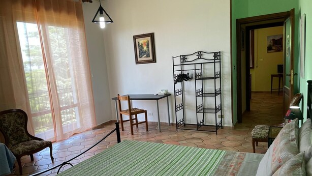 A room with a bed, a chair, a desk, and a metal shelf unit. - Family Suite with 3 Bedrooms | Up to 6 Guests in Monferrato (Tagliolo Monferrato)