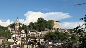 A historic town with a prominent tower, a castle-like structure, and densely packed buildings. - Family Suite with 3 Bedrooms | Up to 6 Guests in Monferrato (Tagliolo Monferrato)