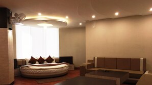 A modern living room with a sofa, a bed, and a coffee table. - Hotel K3 Club Residency (Jhansi)
