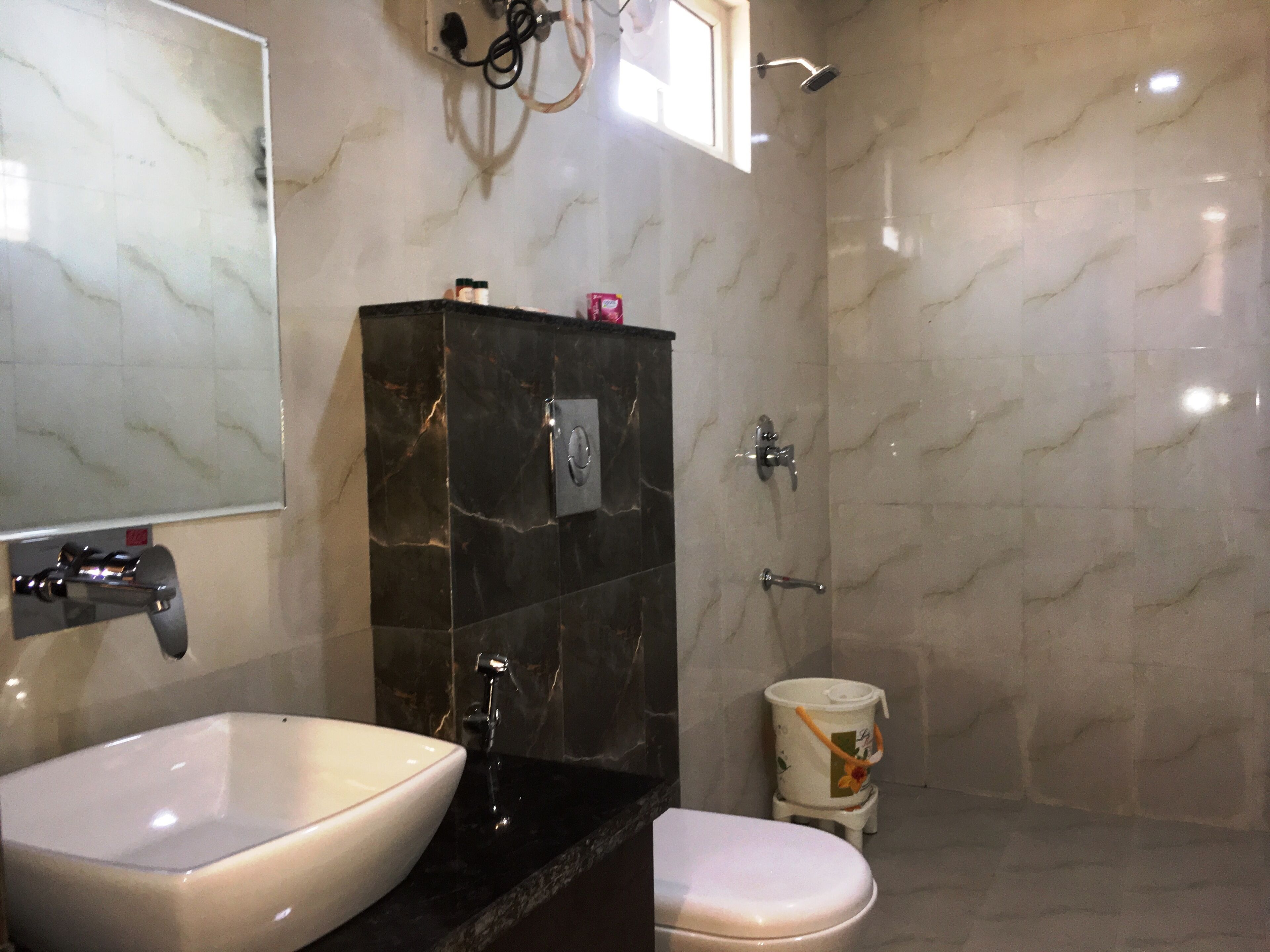 A bathroom with a white sink, a black vanity, a toilet, and a shower.