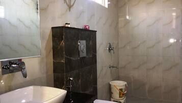 Ein Badezimmer mit weißem Waschbecken, schwarzem Waschtisch, Toilette und Dusche.