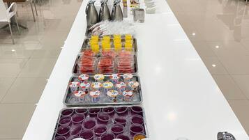 Una barra de buffet con diversos alimentos y bebidas.