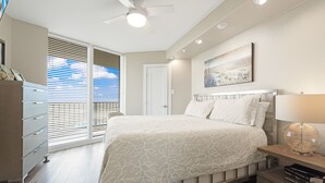 A bedroom with a bed, a nightstand, a dresser, and a ceiling fan.