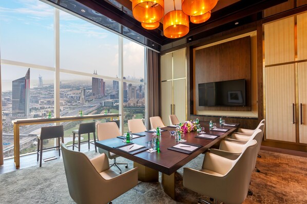 A conference room with a city view, a large table, and modern lighting.
