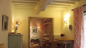 A room with a stone wall, a wooden desk, a chair, a small table with a vase, and a bed. - Private Room in small medieval borgo (Colle di Val d'Elsa)