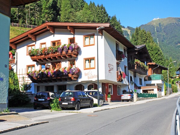 Ein Gebäude mit einem Schild, auf dem „Bed & Breakfast“ steht, und einem Balkon mit Blumenkästen.