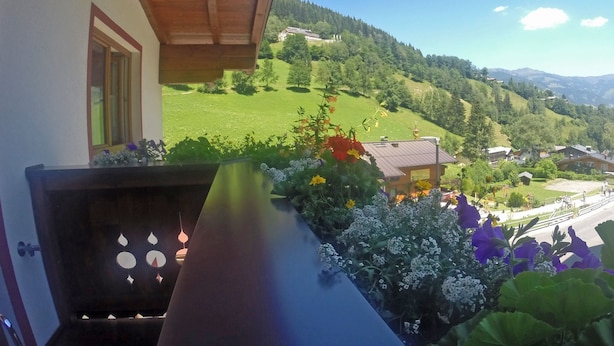 Een balkon met uitzicht op een groene vallei en bergen.