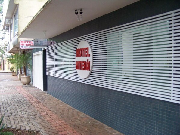 A hotel with a sign reading "HOTEL NITERÓI" and a large circular sign with the same name.