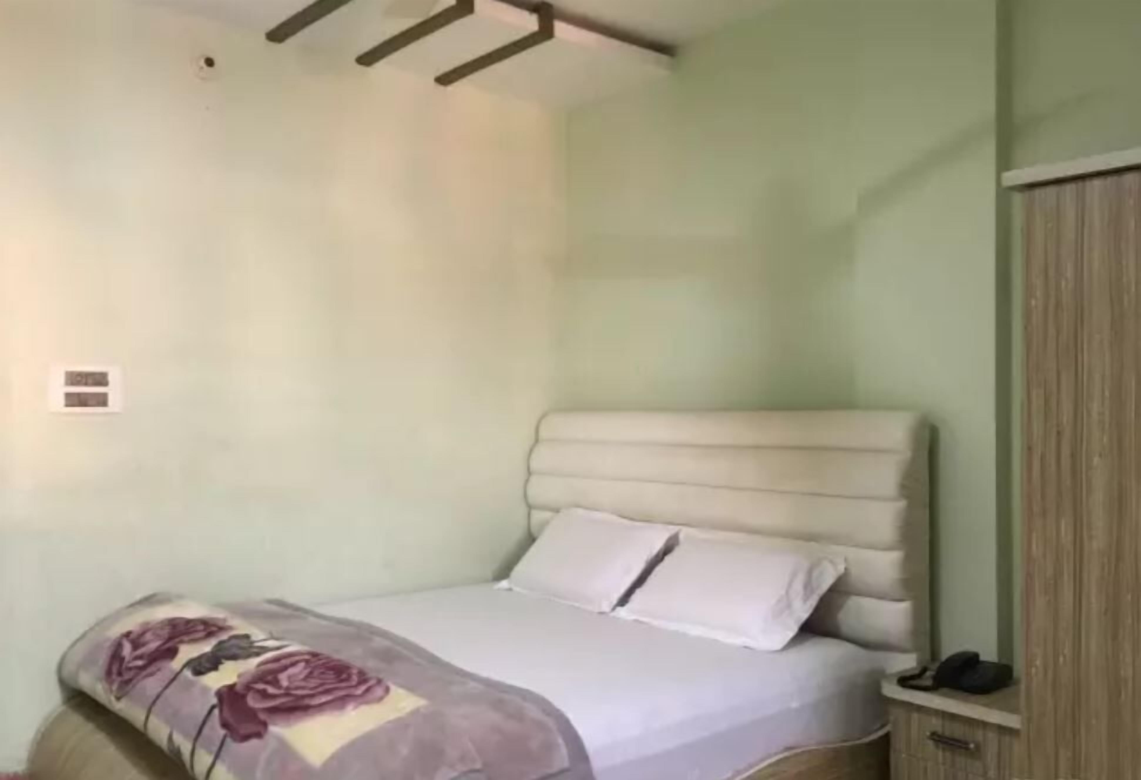 Un dormitorio con cama, mesita de noche y armario.