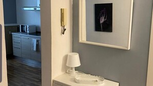 Una cucina moderna con un forno a microonde, un telefono e un quadro appeso al muro.