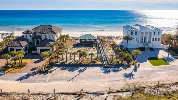 A beachfront property with a large house, a smaller house, and a covered area with a staircase leading to the beach. - Bourbon Breeze - Beachy Home Near the Gulf with Spacious Outdoor Pool Area (Miramar Beach)