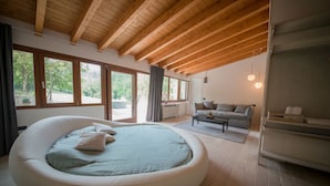 A modern room with a circular bed, a sofa, and a reading area. - Brisighella Green Wellness (Brisighella)