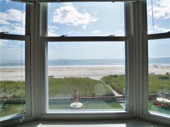 Enjoy a serene beach view from the comfort of your room, with access to an outdoor area featuring a pool and seating.