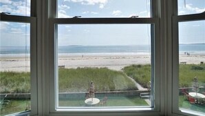 Une pièce dotée d’une grande fenêtre donnant sur une plage.