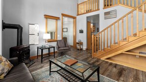 Ein großzügiges Wohnzimmer mit Kamin, einer Treppe und einer gemütlichen Sitzecke.