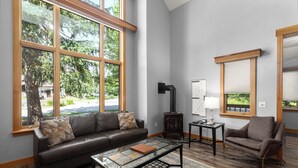 Ein Wohnzimmer mit einer Ledersofa, einem Glastisch und einem Kamin.
