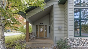 Ein Gebäude mit einer Steinwand und einer Veranda mit Sitzgelegenheiten.