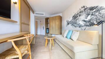 A modern living room with a sofa, a coffee table, a TV, and a wooden cabinet.