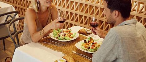 Un tavolo da pranzo con piatti di cibo e bicchieri di vino.