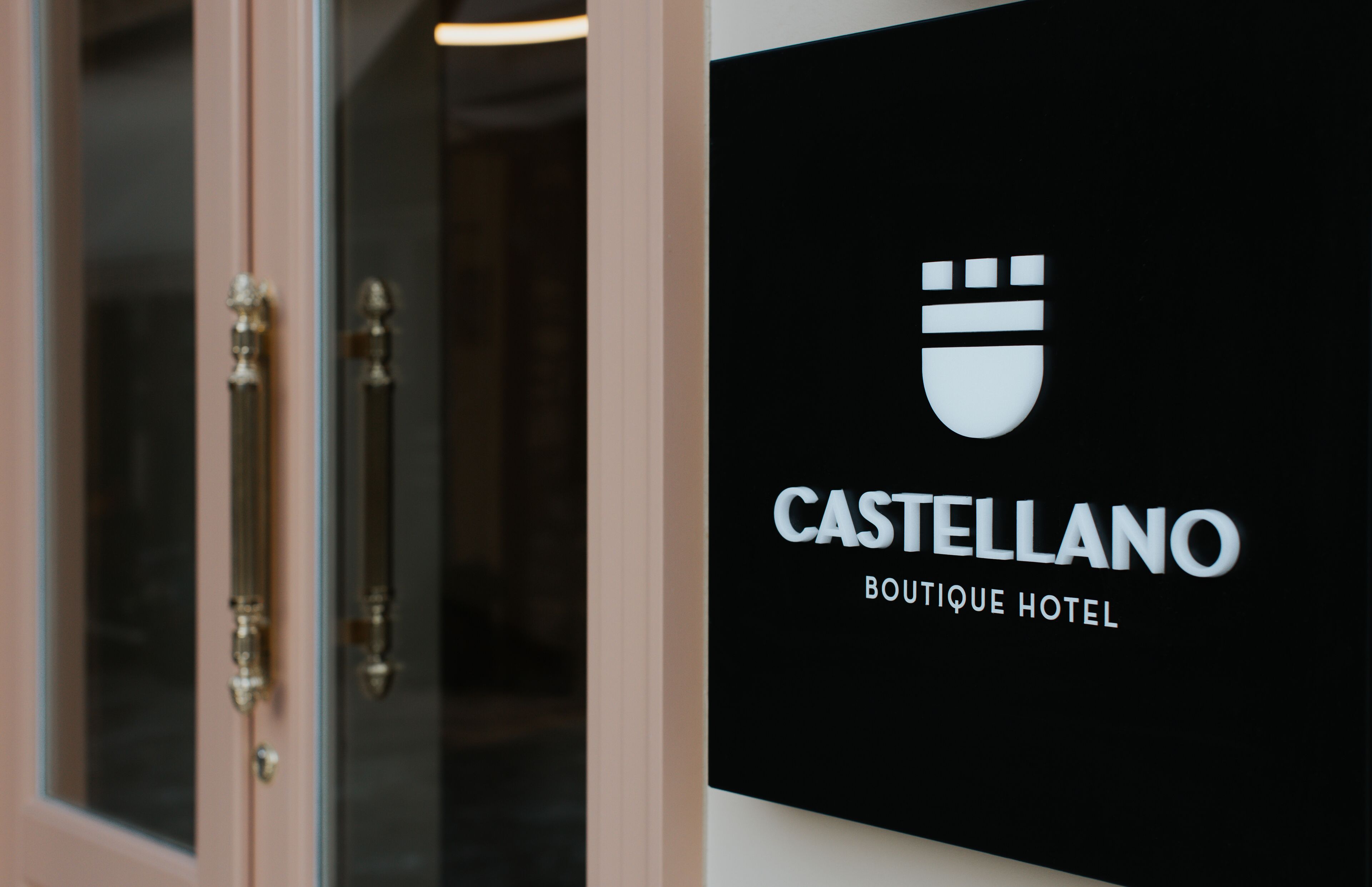 A sign for Castellano Boutique Hotel with a minimalist design and a logo.
