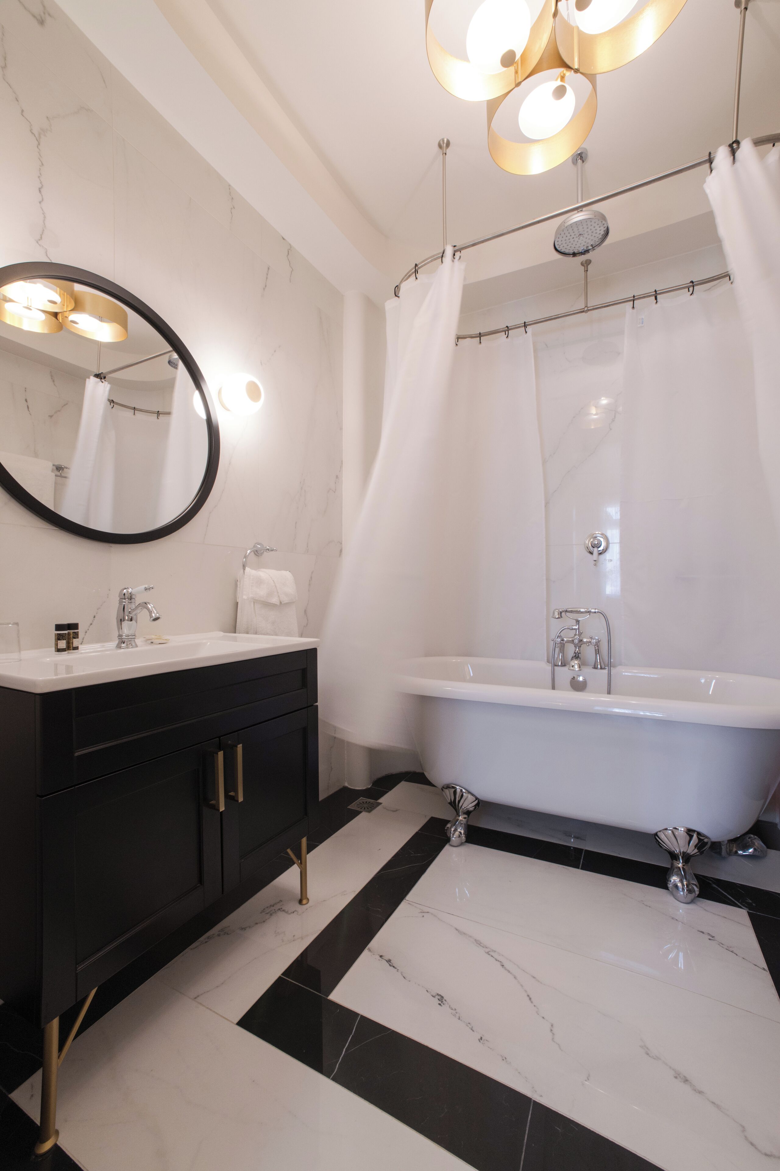 A modern bathroom with a freestanding bathtub, a vanity with a mirror, and a shower curtain.