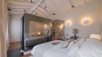 A bedroom with a large bed, a bedside table, a mirror, and a wardrobe.