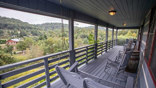 A covered porch with a view of a forested area. - Rustic Cabin in Heart of Boone (Boone)