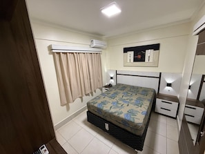 A bedroom with a bed, bedside tables, an air conditioning unit, a mirror, and a curtain. - Lacqua diRoma RM Hospedagem (Caldas Novas)